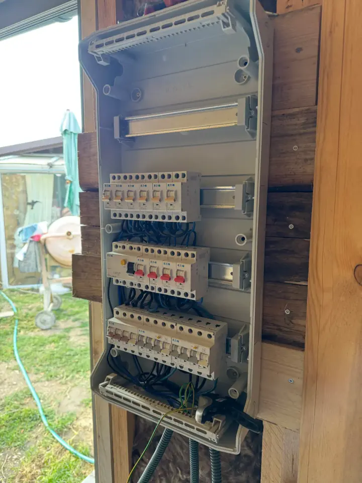Offener Elektroverteiler eines Holzhauses während der Elektroinstallation